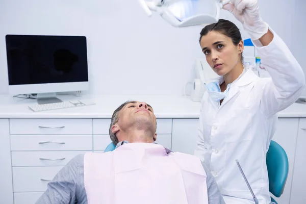 Dentist adjusting electric light — Stock Photo, Image