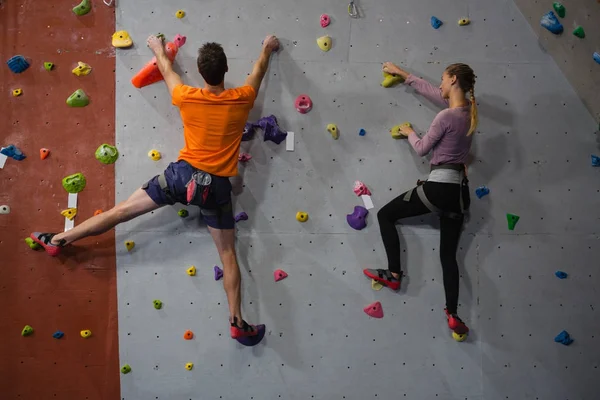 Athletes rock climbing in club — Stock Photo, Image