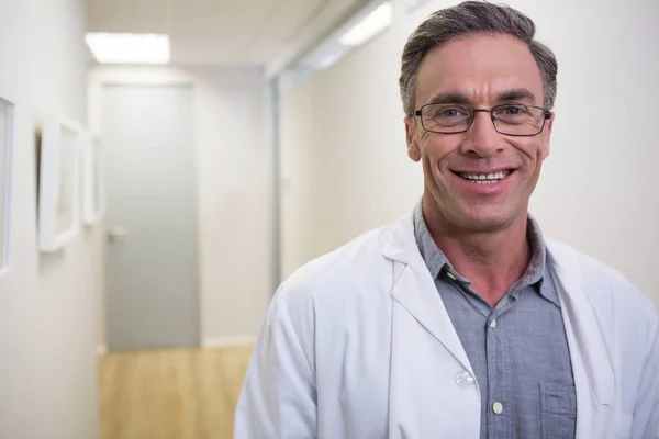 Dentista sonriente de pie en el lobby — Foto de Stock