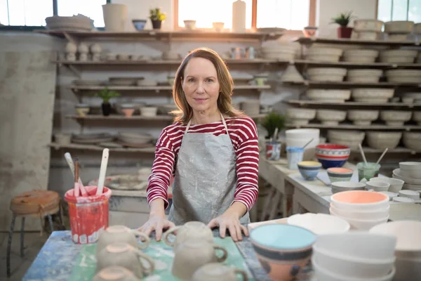 Vrouwelijke potter permanent op het aanrecht — Stockfoto