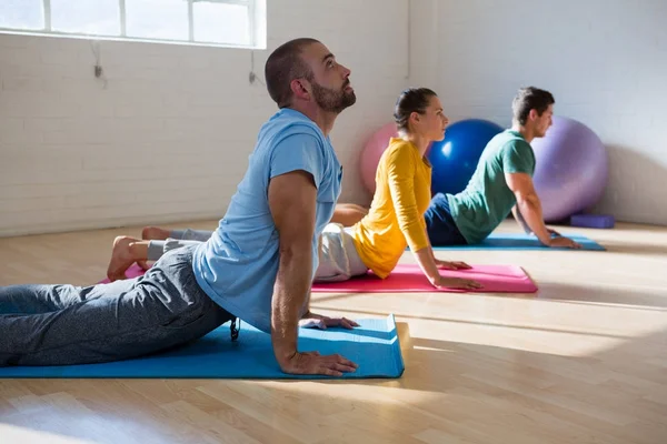 Instruktör med elever öva cobra pose — Stockfoto