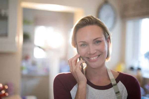 Kobieta, rozmowy na telefon komórkowy w kuchni — Zdjęcie stockowe