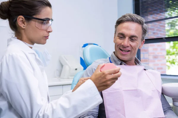 Dentist showing dental mold to man — Stock Photo, Image