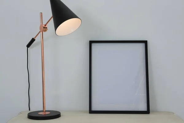 Fotolijst en verlichte lamp op tafel — Stockfoto