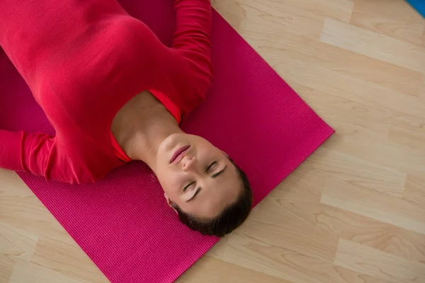 Femme faisant de l'exercice tout en étant couché sur le tapis — Photo