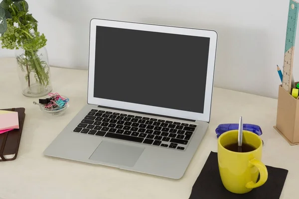 Laptop e vários acessórios de escritório na mesa — Fotografia de Stock