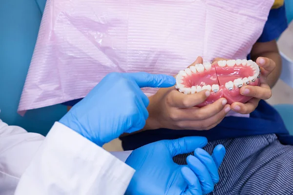 Dentista mostrando dentaduras para menino — Fotografia de Stock