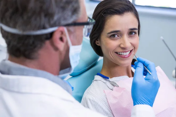 Женщина улыбается во время стоматологического лечения — стоковое фото