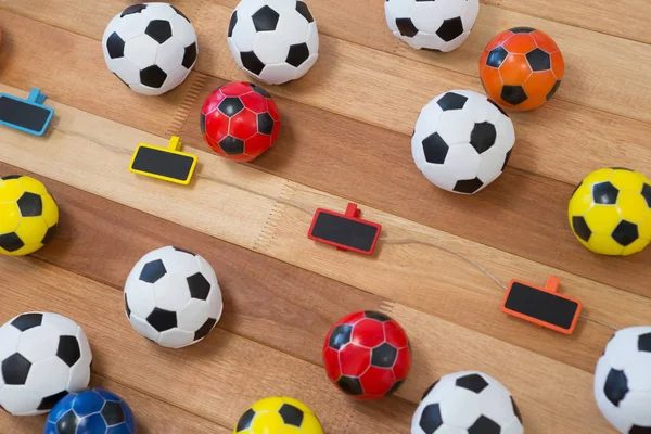 Balles de football colorées sur table en bois — Photo