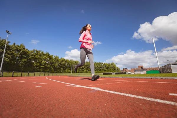 Mujer corriendo en una pista de carreras —  Fotos de Stock