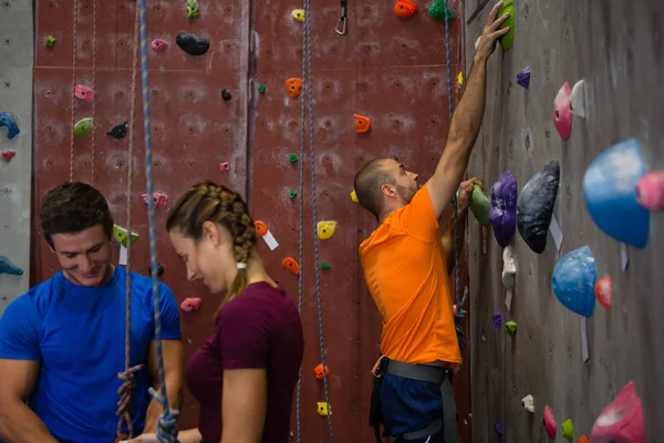 Les athlètes debout près du mur d'escalade de l'entraîneur — Photo