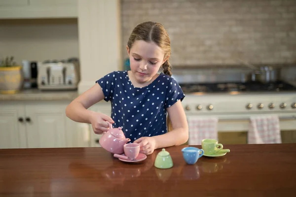 Jong meisje gieten van thee in de cups — Stockfoto