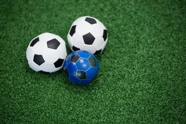 Bolas de futebol na grama artificial — Fotografia de Stock