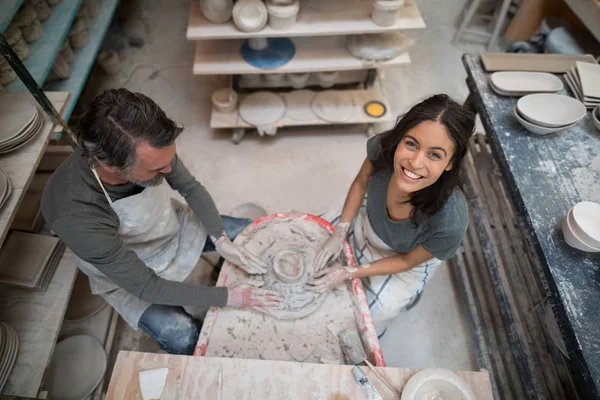 Overhead of male potter assisting female potter — Stock Photo, Image