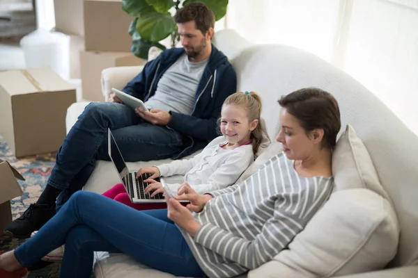 Ouders en dochter met behulp van elektronische apparaten — Stockfoto