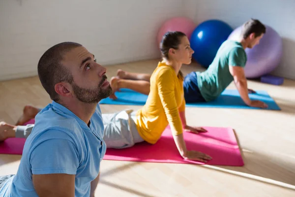 Ausbilder mit Schülern, die Kobra-Pose üben — Stockfoto