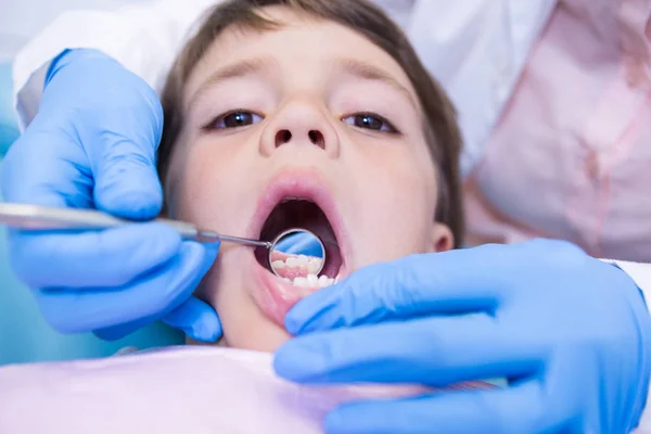 Dentista examinando menino bonito na clínica — Fotografia de Stock