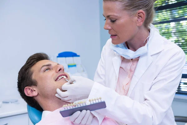 Hasta muayene sırasında ekipman tutarak diş hekimi — Stok fotoğraf