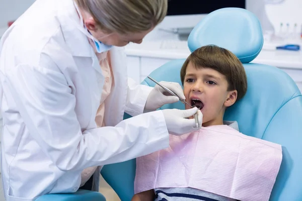 Boy receiving dental treatment by dentist — Stock Photo, Image