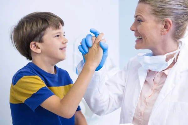 Leende tandläkare leker med pojke — Stockfoto