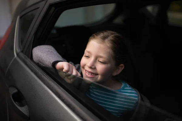 Adolescente regardant par la fenêtre de la voiture — Photo