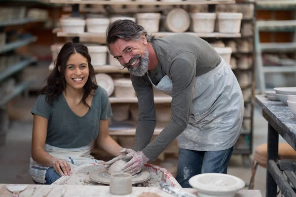 Male potter assisting female potter — Stock Photo, Image