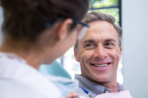 Happy patient looking at dentist — Stock Photo, Image