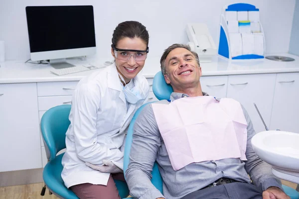 Dentista e paziente seduto sulla sedia — Foto Stock