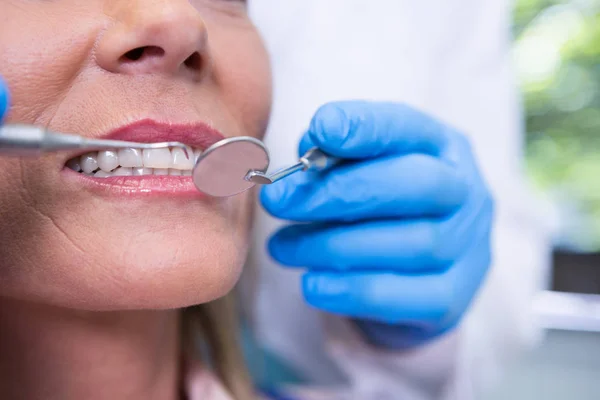 Dentista examinando a mujer en clínica médica —  Fotos de Stock