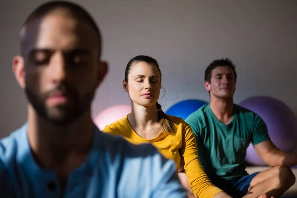 Istruttore con studenti che meditano in posizione di loto — Foto Stock