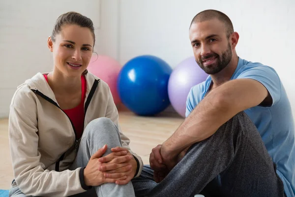 Estudiante e instructor relajante en estudio de yoga — Foto de Stock