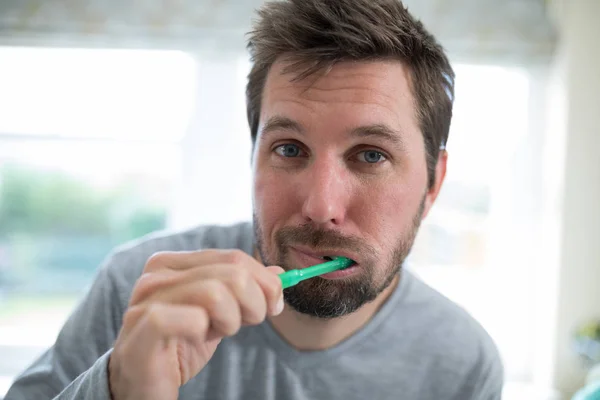 Мужчина чистит зубы в ванной — стоковое фото
