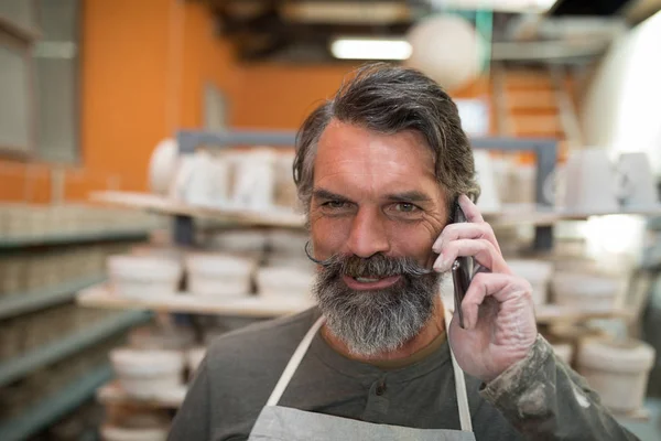 Hombre alfarero hablando en el teléfono móvil — Foto de Stock