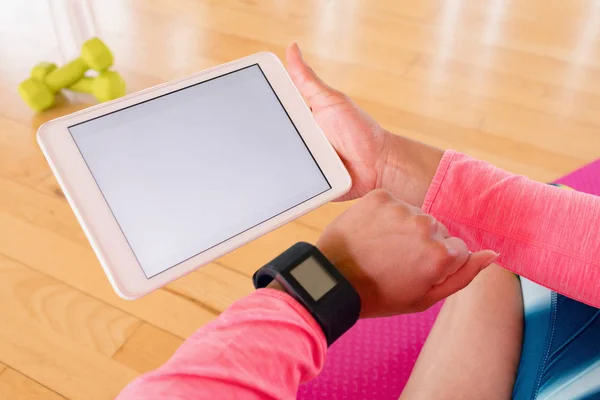 Женщина держит планшет в то время как США умные часы — стоковое фото