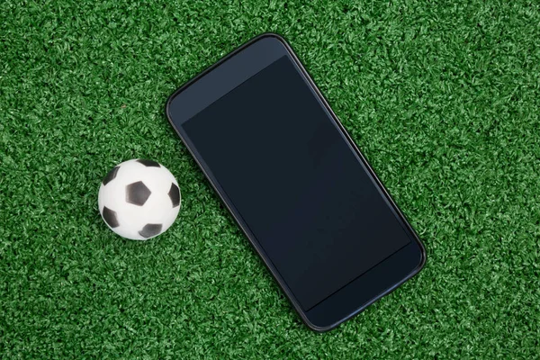 Fotbal și telefon mobil pe iarbă artificială — Fotografie, imagine de stoc