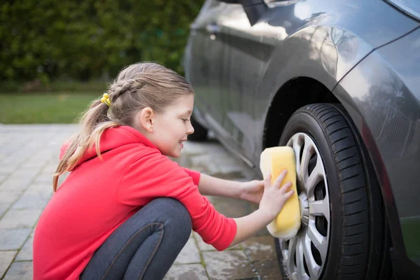 Adolescente menina lavar um carro no dia ensolarado — Fotografia de Stock