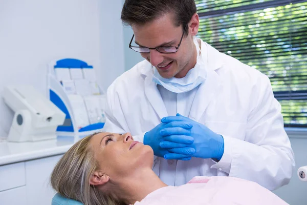 Odontólogo sonriente mirando al paciente — Foto de Stock