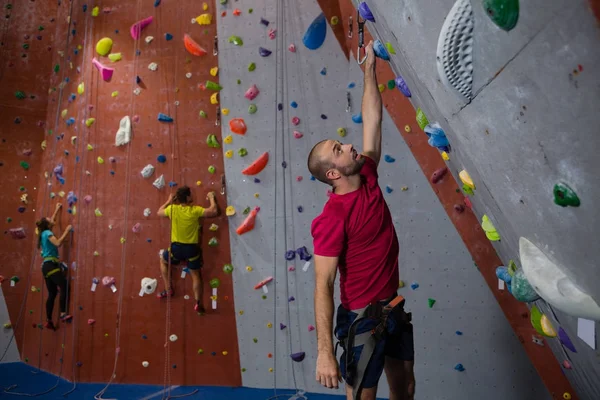 Sportovci a trenér lezeckou stěnou v klubu — Stock fotografie