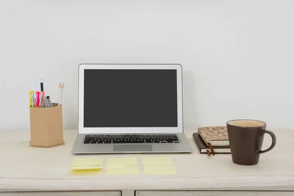 Laptop e vários acessórios de escritório na mesa — Fotografia de Stock