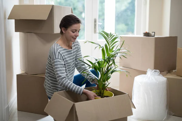 Mujer abrir cajas de cartón en la sala de estar — Foto de Stock
