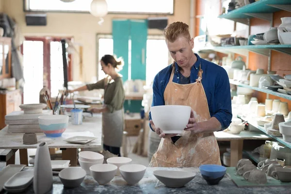 Male potter checking ceramic bowl — Stock Photo, Image