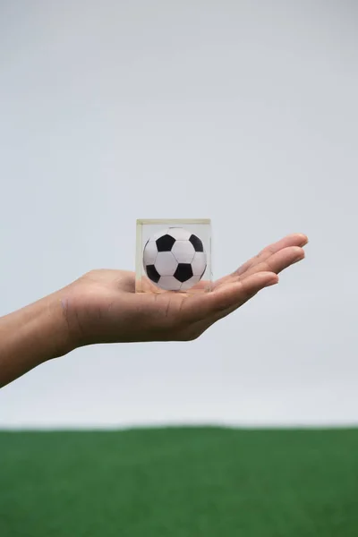 Hand innehav akryl fotboll kub — Stockfoto