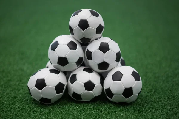Stack of piled up football soccer balls — Stock Photo, Image