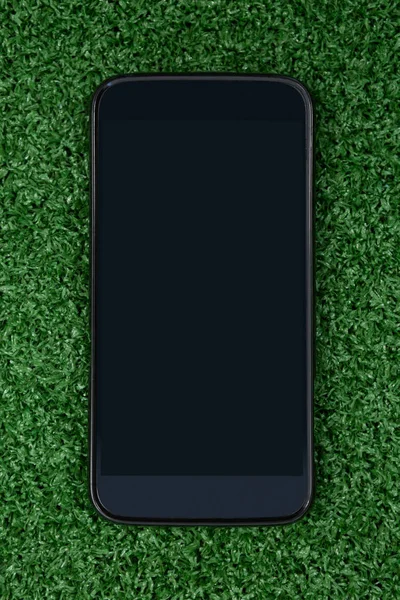 Мобильный телефон на искусственной траве — стоковое фото