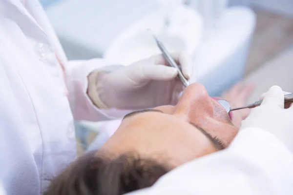 Dentysta, dając człowiekowi leczenie stomatologiczne — Zdjęcie stockowe