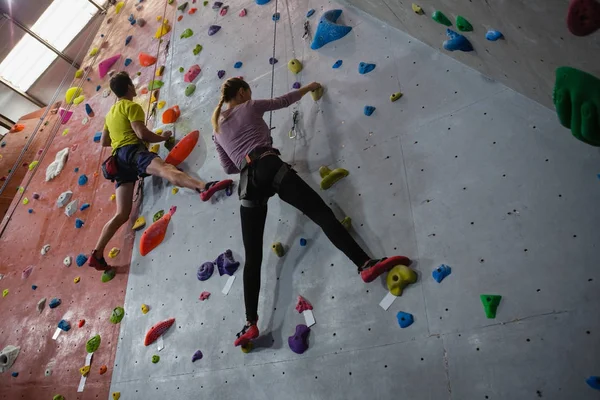 Athletes rock climbing in fitness club — Stock Photo, Image