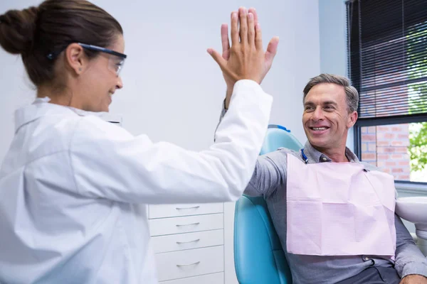 Dentista dando alta cinco para o homem — Fotografia de Stock