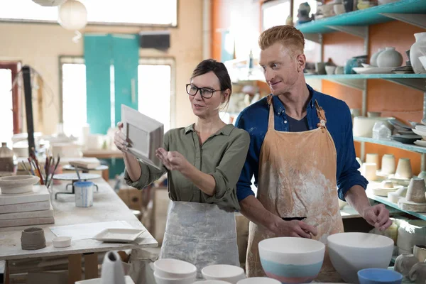 Male and female potter checking plate — Stock Photo, Image