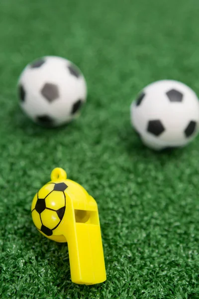 Assobio e bolas de futebol na grama artificial — Fotografia de Stock
