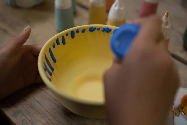 Handen van meisje schilderij kom — Stockfoto